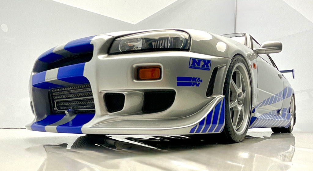 Dettaglio anteriore dal basso della Nissan Skyline R34, con griglia, prese d’aria e paraurti