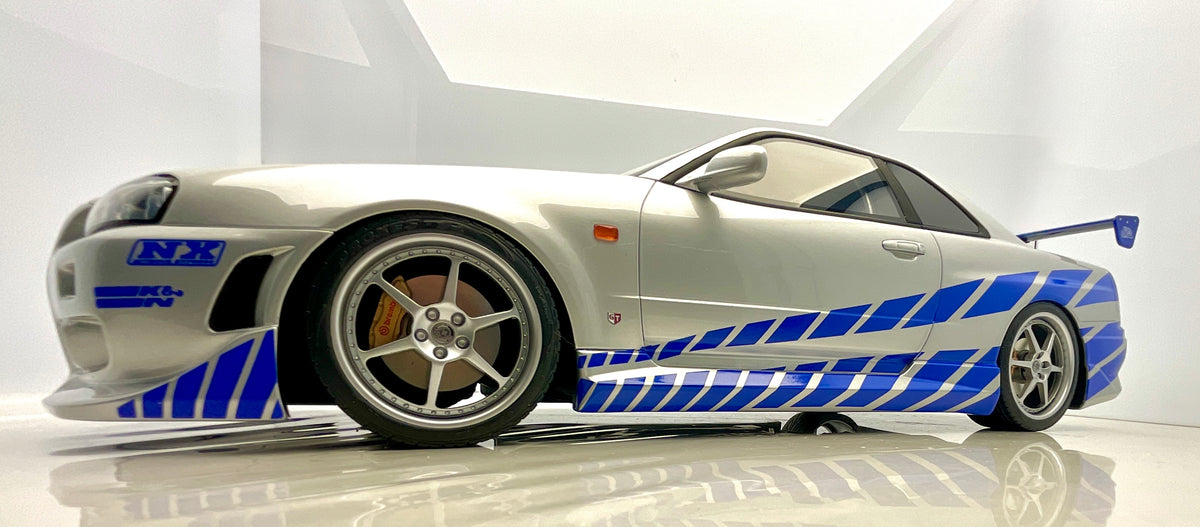 Vista laterale a bassa angolazione della Nissan Skyline R34 GT-R di Brian O’Conner, con livrea blu.