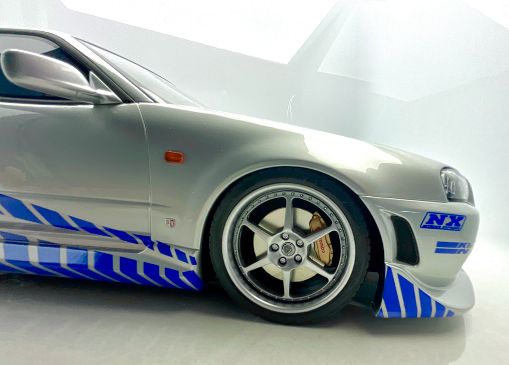 Dettaglio della ruota anteriore e della grafica NX sul paraurti della Nissan Skyline R34.