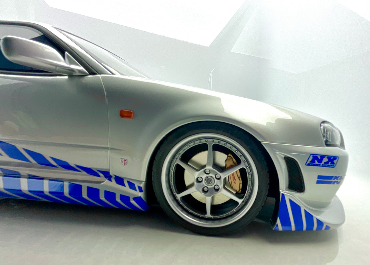 Dettaglio della ruota anteriore e della grafica NX sul paraurti della Nissan Skyline R34.
