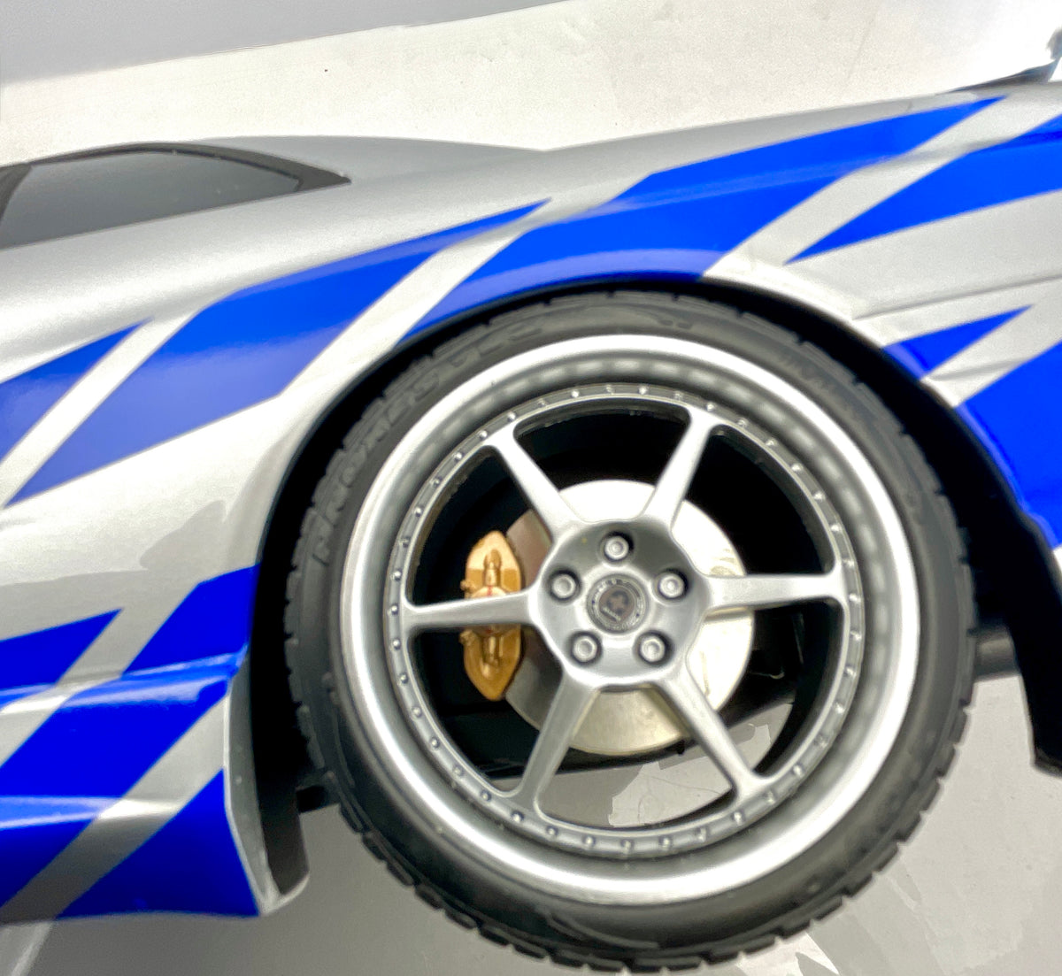  Dettaglio della ruota a cinque razze, del passaruota e delle grafiche blu sulla Nissan Skyline R34.