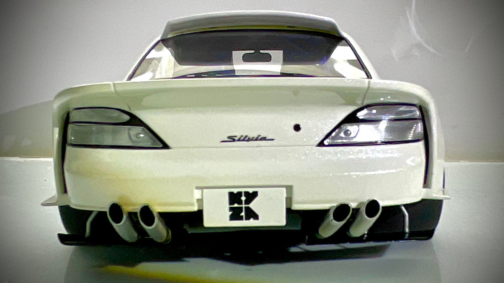 Vista posteriore della Kyosho Nissan Silvia S15 bianco perlato, con alettone e quattro terminali di scarico