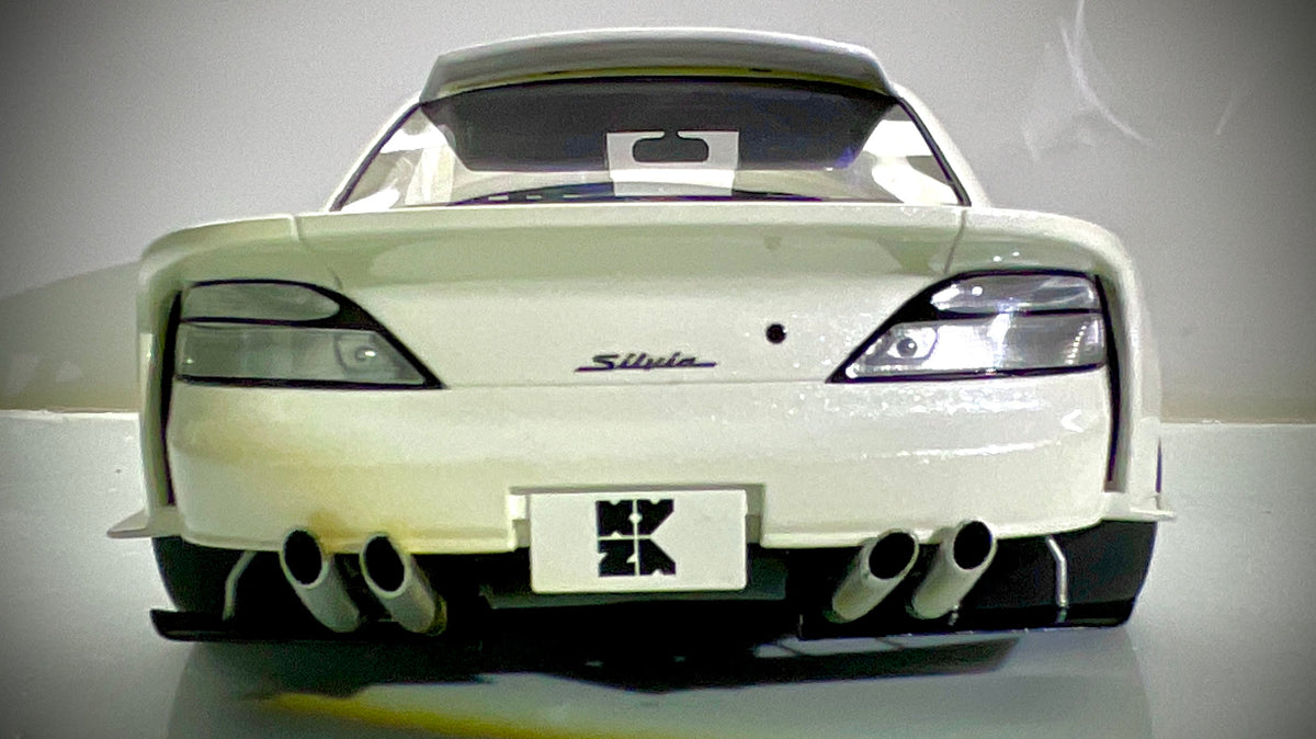 Vista posteriore della Kyosho Nissan Silvia S15 bianco perlato, con alettone e quattro terminali di scarico