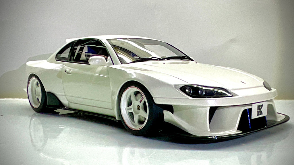 Vista anteriore a tre quarti dal lato opposto della Nissan Silvia S15 Kyosho bianco perlato.