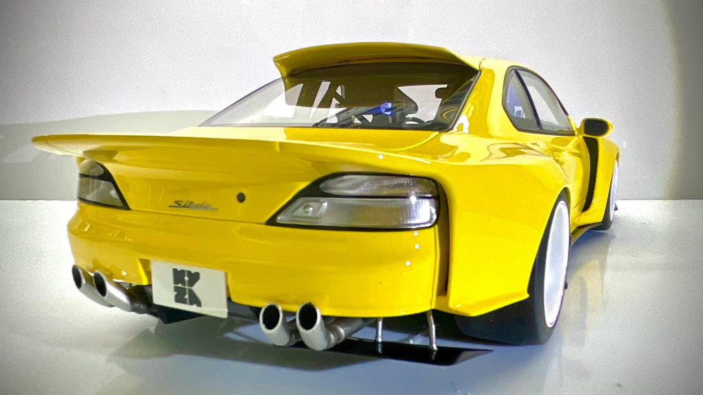 Nissan Silvia S15 Khyzyl Saleem gialla, vista posteriore a tre quarti dal lato opposto.