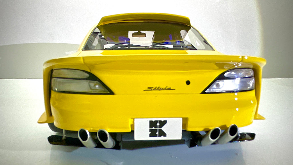 Vista posteriore del modellino Kyosho Nissan Silvia S15 gialla.