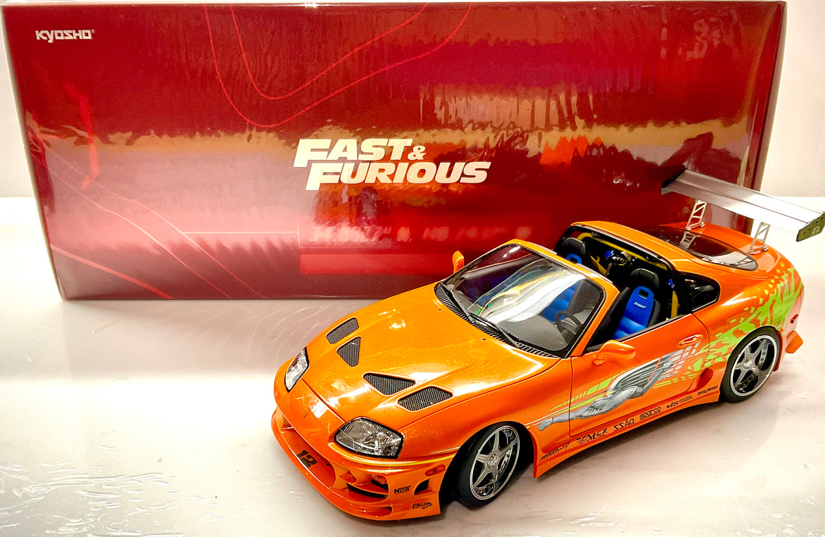  Toyota Supra Fast & Furious arancione Kyosho 1:18, vista anteriore dall’alto con tettuccio rimosso e scatola.