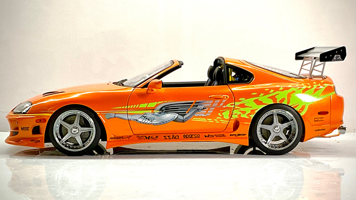 Toyota Supra Fast & Furious Kyosho, profilo sinistro con grafiche laterali, cerchi a cinque razze e alettone.