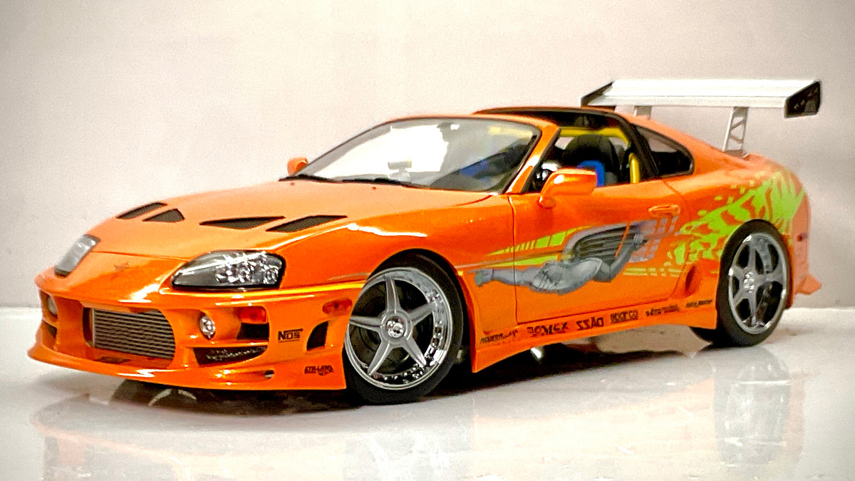 Toyota Supra Fast & Furious arancione Kyosho, vista anteriore di tre quarti con prese d’aria sul cofano.