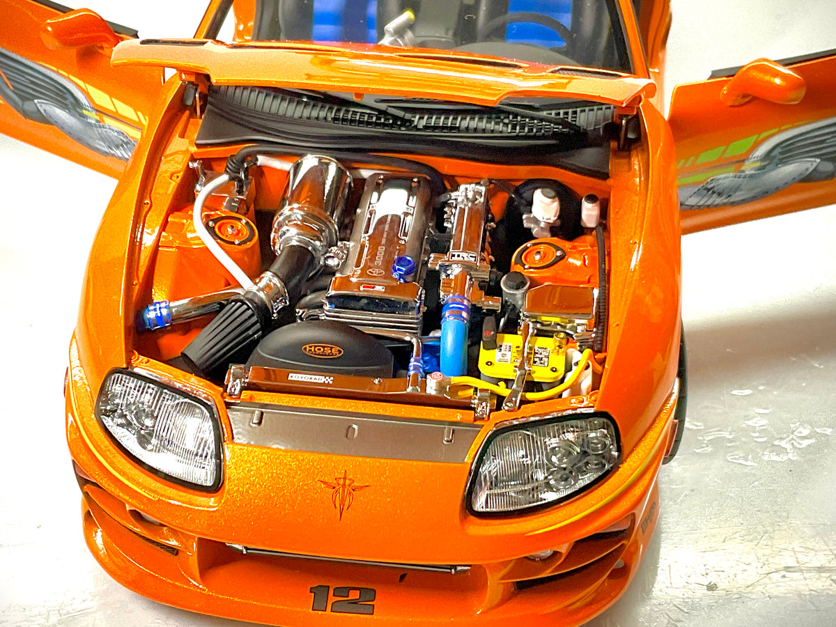  Dettaglio del vano motore della Toyota Supra Fast & Furious Kyosho, con cofano aperto e tubazioni blu.