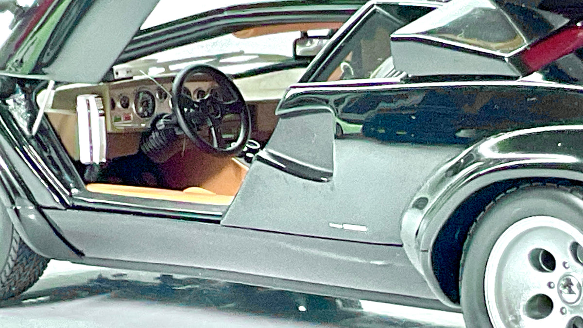 Interni della Lamborghini Countach LP 400S Kyosho, con telefono di bordo, volante e portiera aperta.