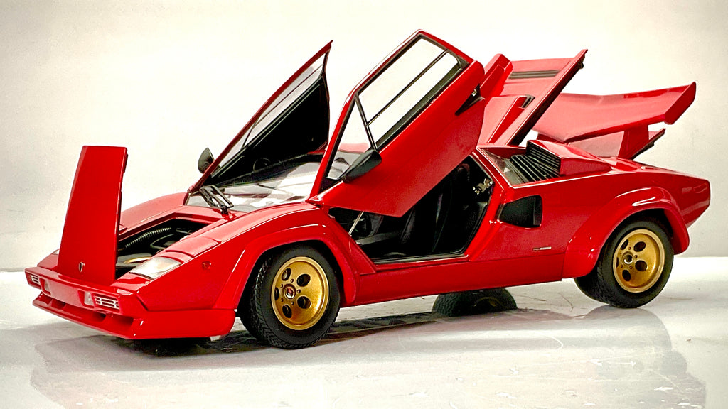 Lamborghini Countach rossa Kyosho con portiere verticali e cofani aperti, vista anteriore di tre quarti.
