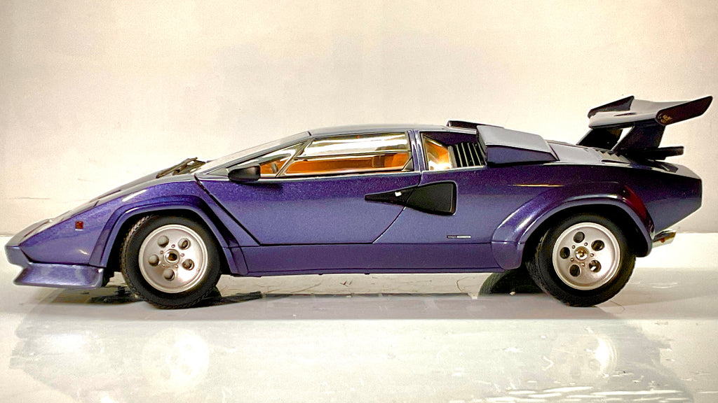  Lamborghini Countach Kyosho blu scuro, vista laterale con cerchi argento e alettone posteriore.